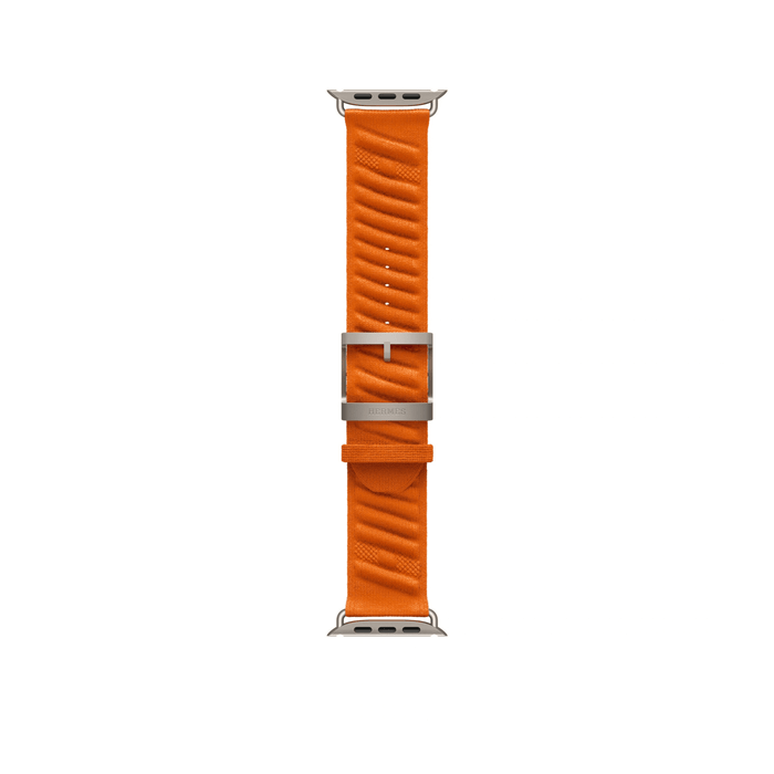 Orange 49mm Hermès En Mer Apple Watch band laid flat, showing the patterned fabric, titanium buckle and adjustment holes.