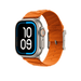 Orange Hermès En Mer band fitted to an Apple Watch Ultra, shown at an angle highlighting the textured fabric and titanium buckle.