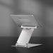 Portable silver laptop stand with adjustable height, shown with a laptop, available at TaMiMi Projects in Qatar.